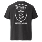 Back view of a dark heather gray Build It Boldly unisex organic ribbed-neck t-shirt with white “Optimism Protect Yours” shield graphic on a plain background.