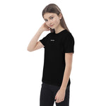 Teen wearing a black Build It Boldly organic cotton t-shirt with small white chest logo, shown in angled side model view.