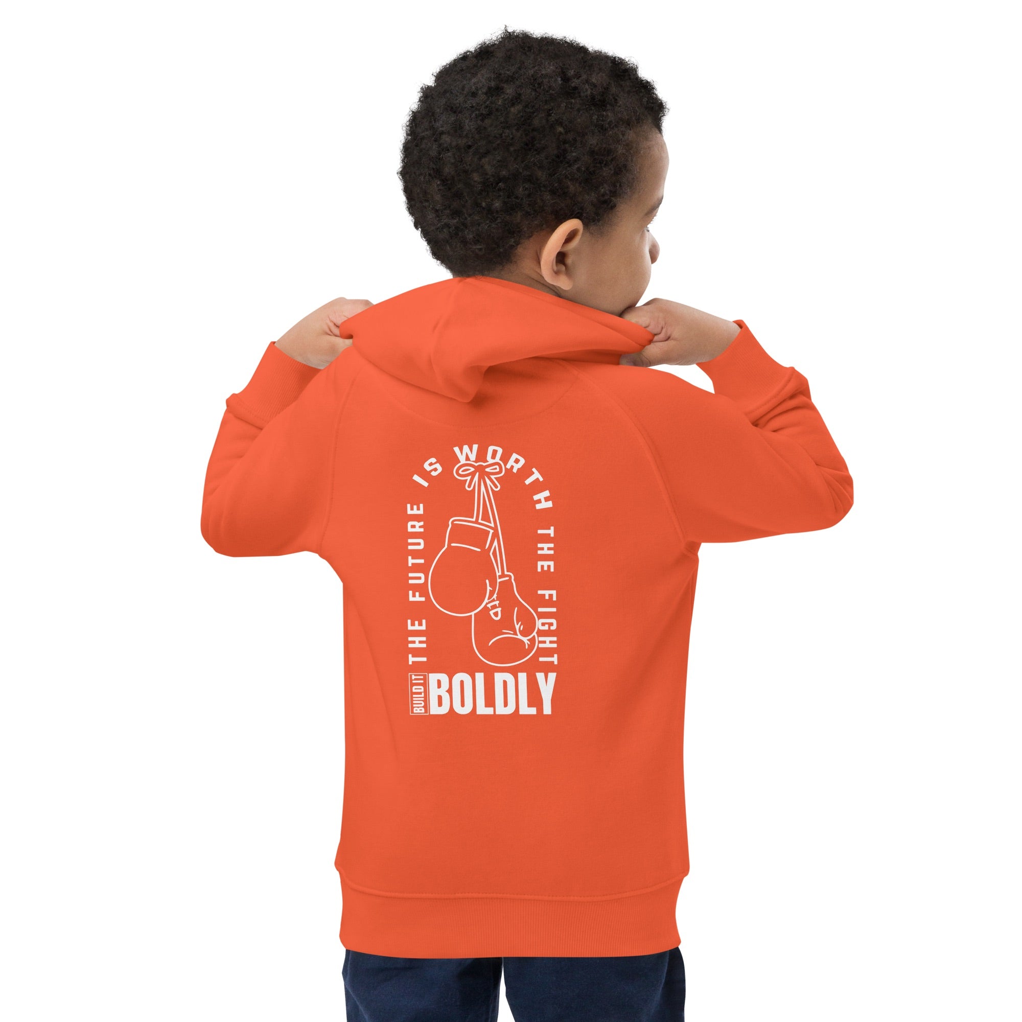 Back view of a child wearing a burnt orange Build It Boldly kids hoodie with boxing gloves graphic and the phrase “The Future Is Worth the Fight.”