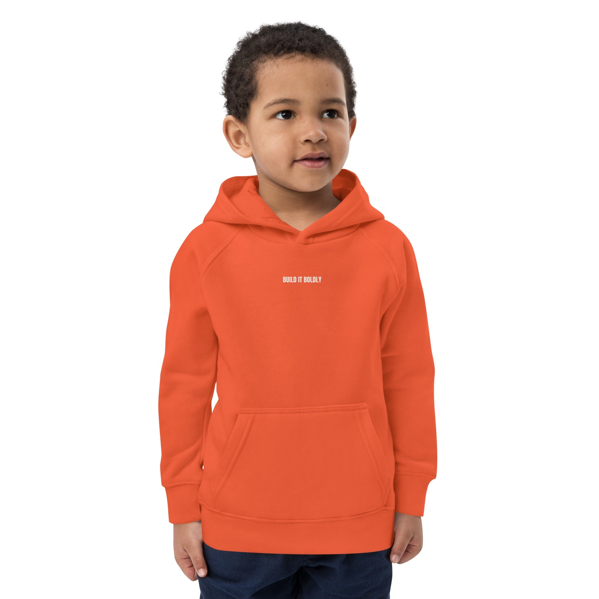 Front view of a child wearing a burnt orange Build It Boldly kids hoodie with small white chest logo.