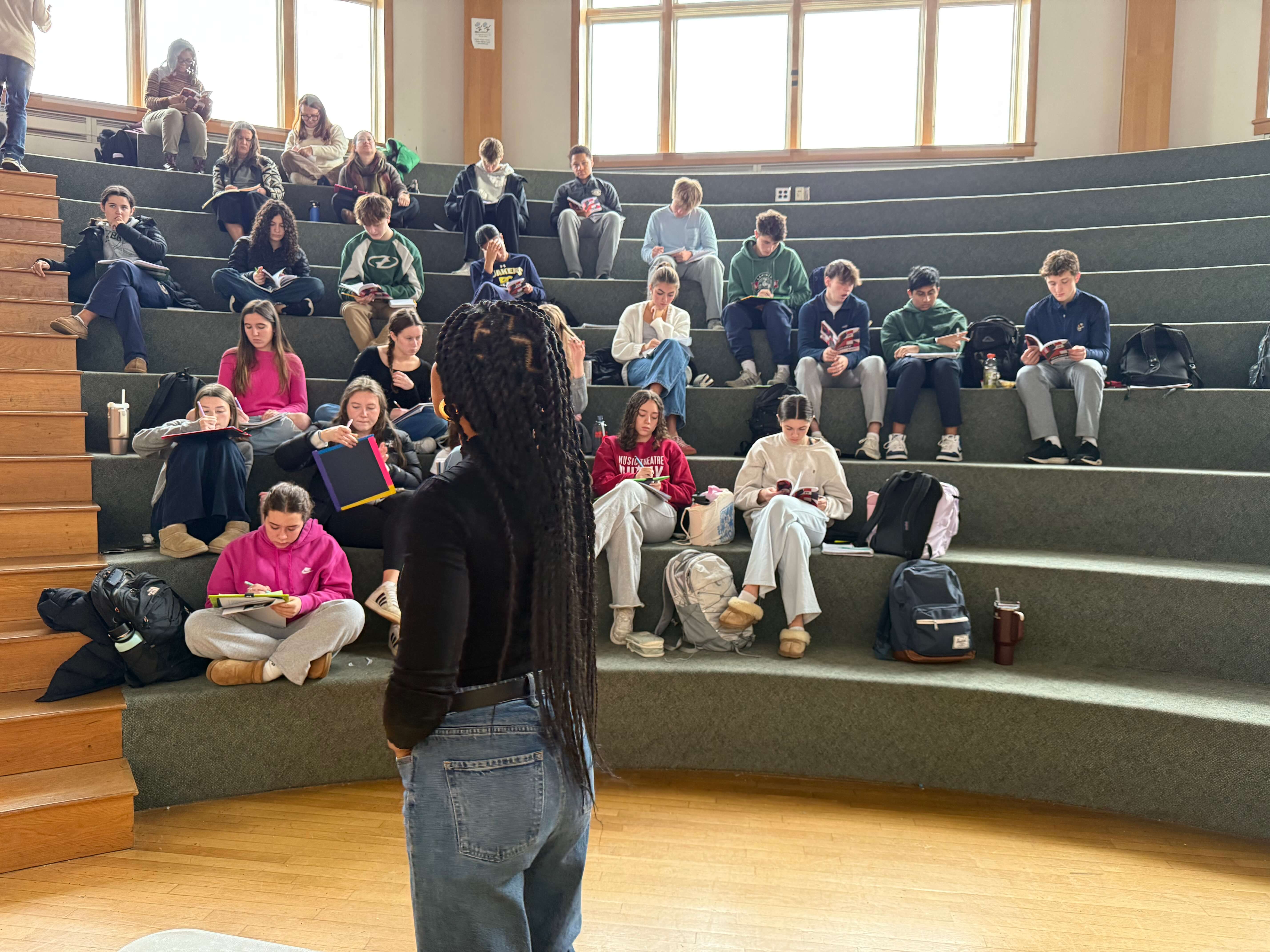 Build It Boldly facilitator speaking to students during an interactive leadership workshop in an auditorium.