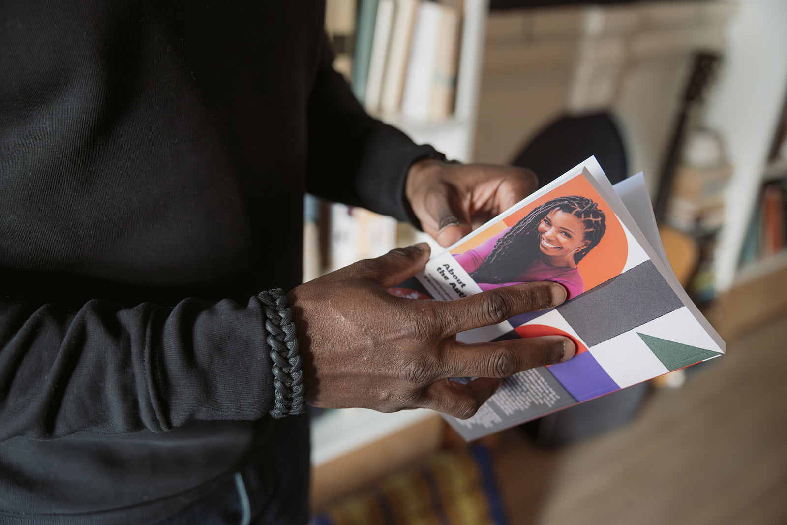 Hands holding an open promotional postcard featuring Dr. Kimberly McGlonn and Build It Boldly branding.