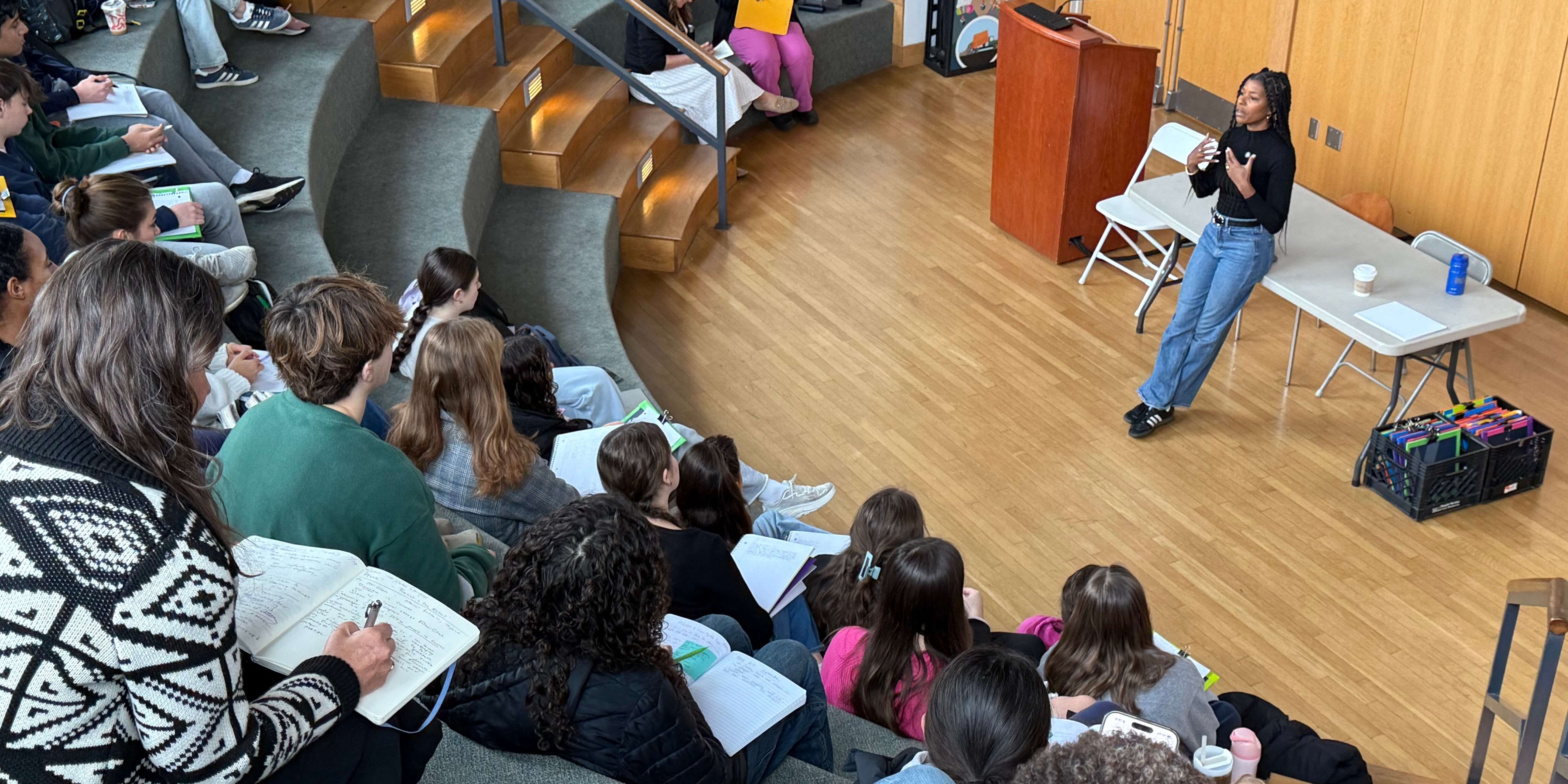 Build It Boldly speaker leading a student leadership workshop in an auditorium while participants take notes.