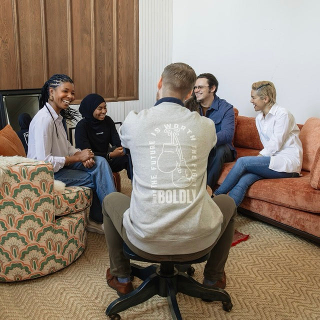 Diverse group of professionals in a leadership circle engaged in conversation, building trust and community