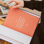 Hand opening The Leader’s Work workbook to an affirmation page with the message, “I honor tenderness as a source of strength in life and in leadership.