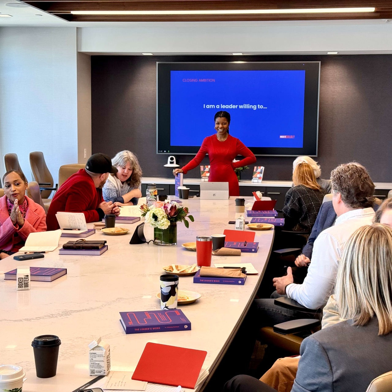 Leadership workshop with Kimberly McGlonn presenting to group, participants engaging with The Leader’s Work journals in a conference setting