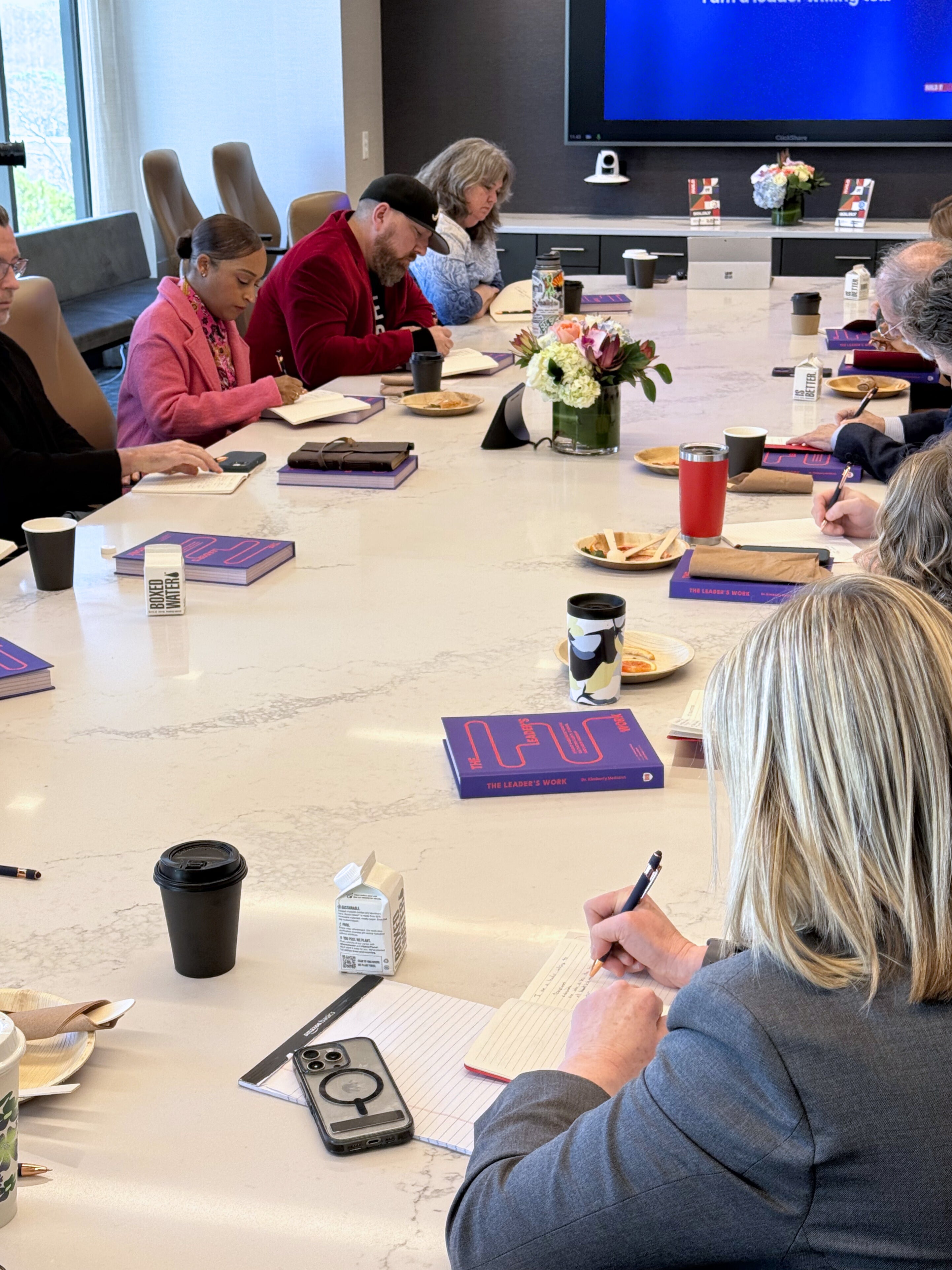 Participants writing reflections during a Build It Boldly leadership development workshop using The Leader’s Work workbook.