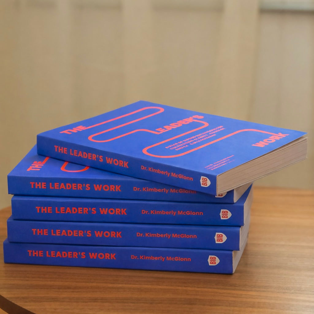 Stack of The Leader’s Work by Dr. Kimberly McGlonn on a table, showcasing guided leadership workbook for reflection and growth