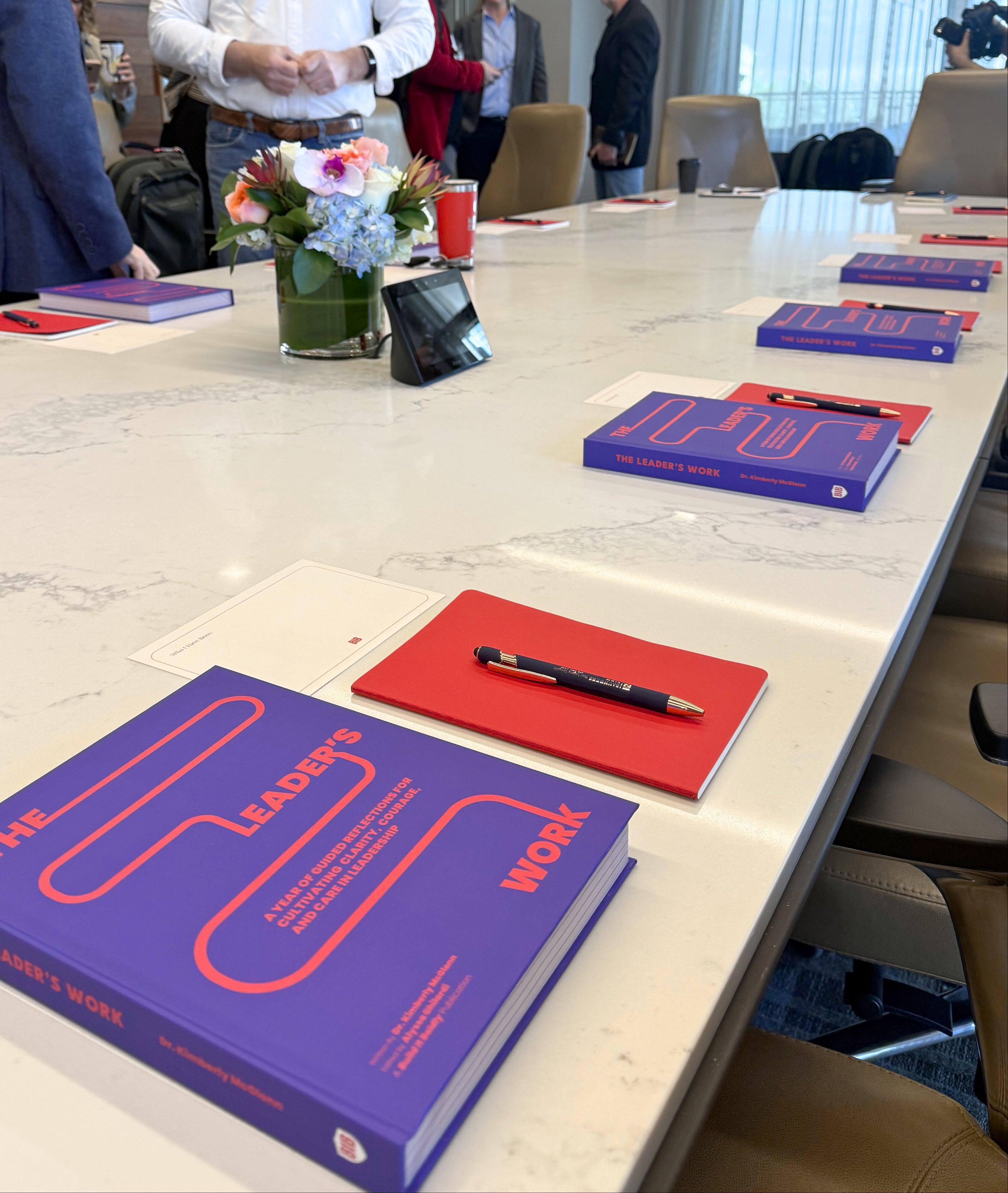 Copies of The Leader’s Work leadership workbook placed on a conference table for a Build It Boldly workshop.