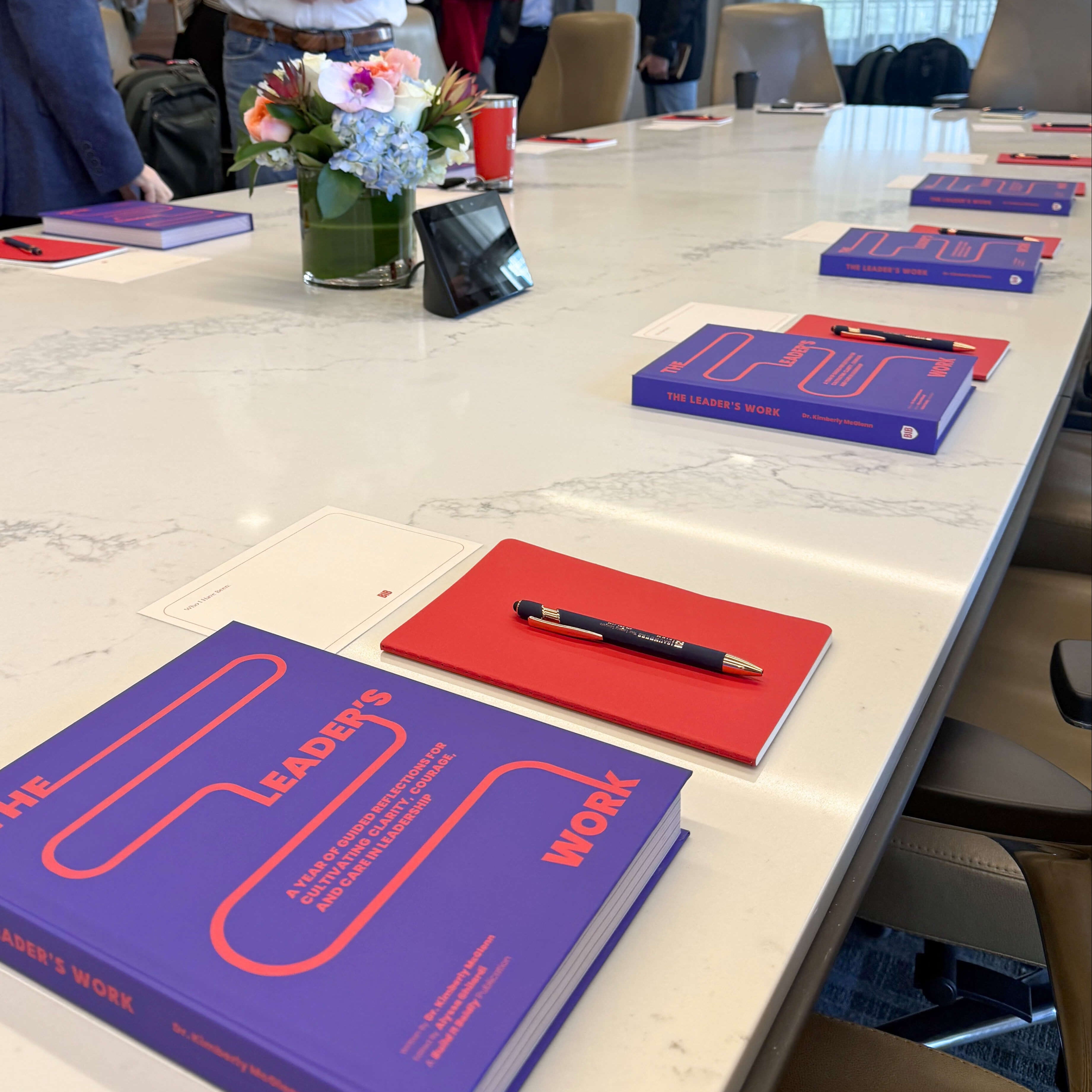 Copies of The Leader’s Work leadership workbook placed on a conference table for a Build It Boldly workshop.